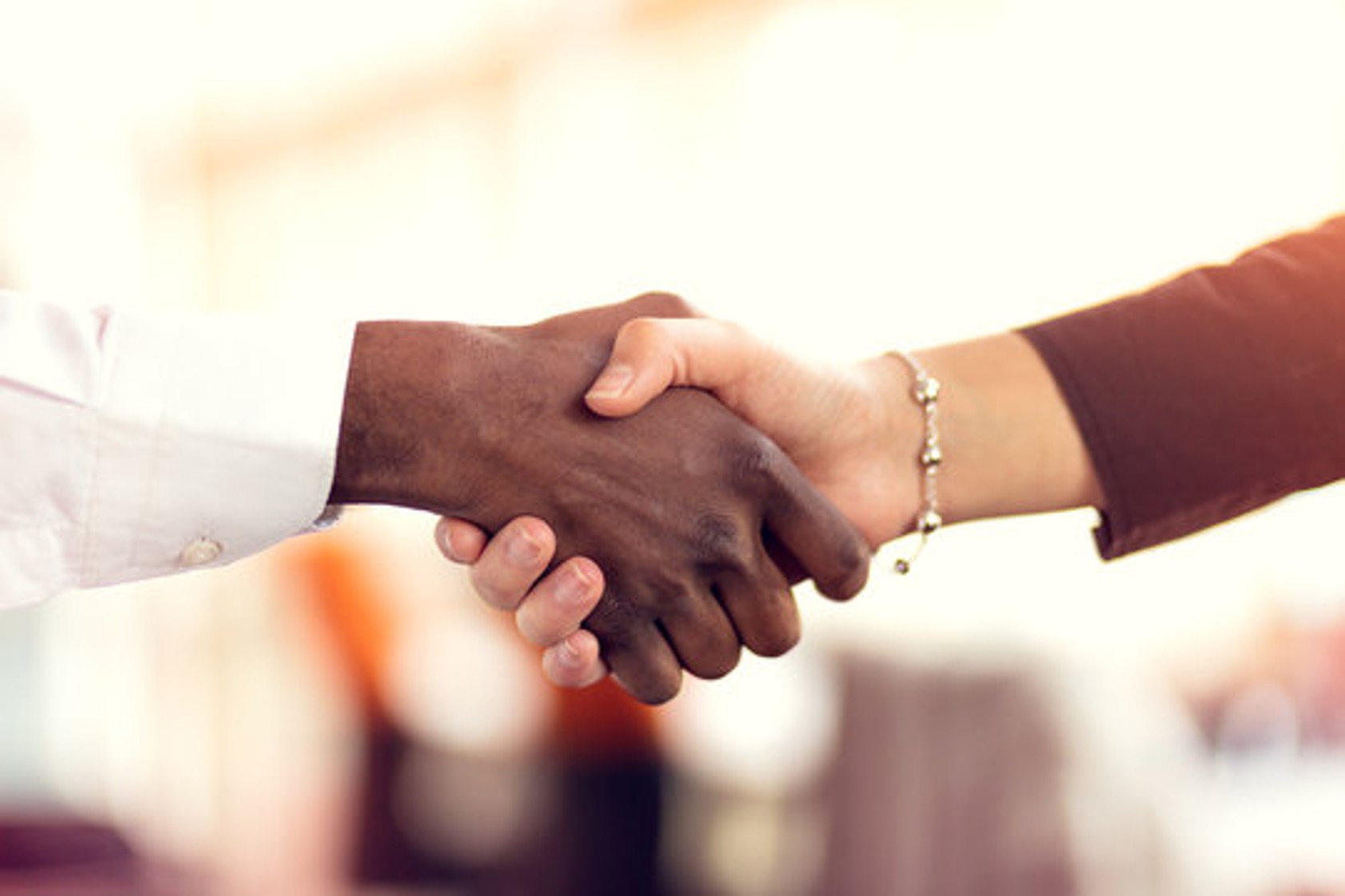 Close up of diverse people shaking hands